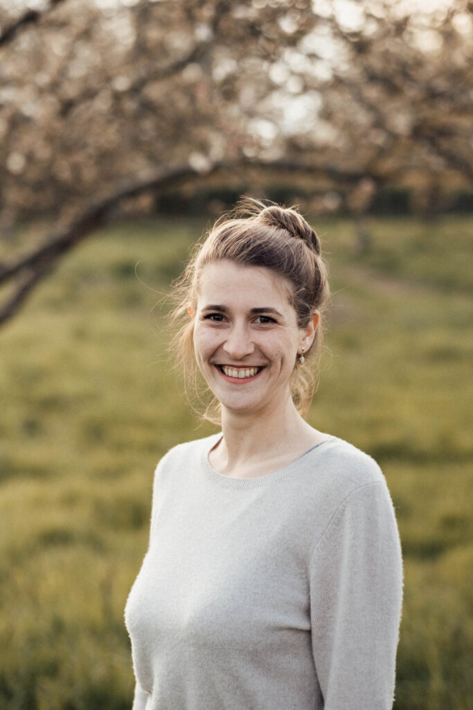 Porträt von Annika Haack, Hebamme und Stillberaterin aus Aachen, lächelnd im Grünen